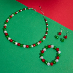 Detailed view of Christmas jewelry set with red, green and white pearls and gold charms