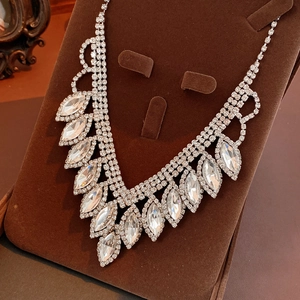 Macro shot of silver V-shaped necklace with marquise rhinestones on velvet display