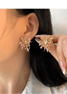 Detail of red flower stud earring with heart zircon stone worn on model's ear