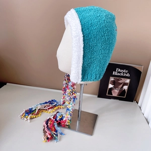 Detailed macro view of plush knitted winter hat with colorful long fringe tassels and trim