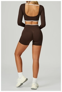 Detail of coffee yoga top featuring seamless U-shaped back cutout and white contrast trim
