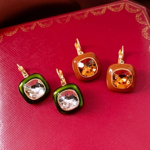 Detail view of 18k gold plated vintage square earrings with crystal on luxury red box