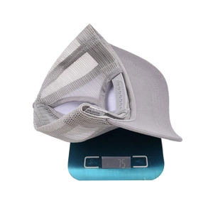 Detailed view of lightweight 75g breathable mesh ponytail trucker hat on digital scale