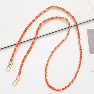 Detail of orange leather and gold chain woven shoulder strap with rotating lobster clasps