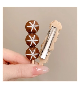 Detailweergave van de grappige haarclip met paddenstoelen en een metalen eendenbek
