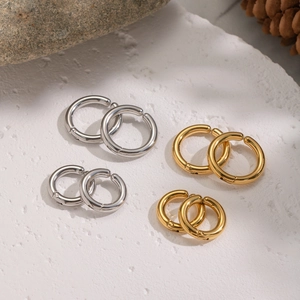 Minimalist 18K gold and silver stainless steel ear cuffs set on a natural stone background