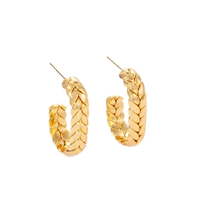 Macro view of gold-tone C-shape earrings featuring intricate braided texture detail