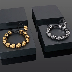 Detail of silver and gold skull beaded bracelets with adjustable black braided rope
