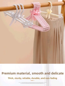 Detail of elegant pearl hangers with ribbon bows and clips for children's clothes