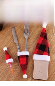 Detail of red and black buffalo plaid mini Christmas hats used for cutlery and phone decor