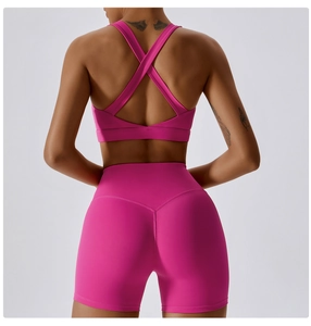 Dettaglio del reggiseno sportivo con incrocio e pantaloncini push-up a vita alta rosa