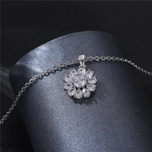 Silver snowflake flower necklace with cubic zirconia pendant on grey display