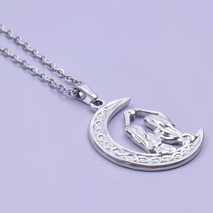 Close-up of crescent moon pendant with hugging figures in polished silver finish