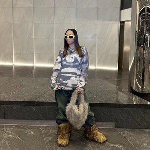 Street style view of a fluffy heart-shaped faux fur bag paired with oversized plush boots