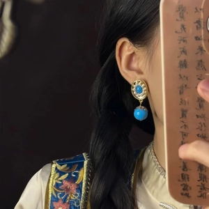 Vintage gold oval pearl earrings with blue stones and beads worn by a female model