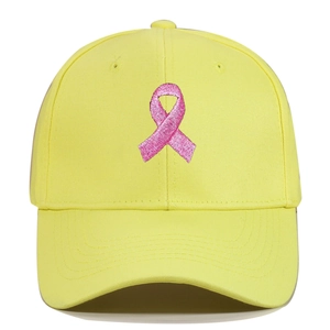 Detail of pink ribbon embroidery on yellow cotton twill baseball cap with fine stitching
