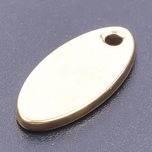 Macro shot of oval gold stainless steel pendant with smooth polished finish for DIY jewelry