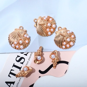 Detailed view of KC gold sea shell pendants with starfish accents and white pearls