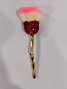 Detail view of rose-shaped makeup brush with red rhinestones and soft gradient pink bristles