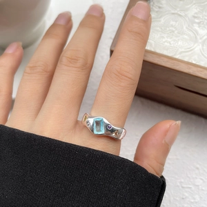 Detail of an irregular S925 silver ring featuring a blue rectangular gemstone on hand