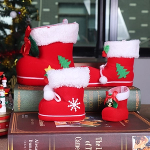 Detailed view of four red flocked Christmas candy boots on vintage books for holiday decor