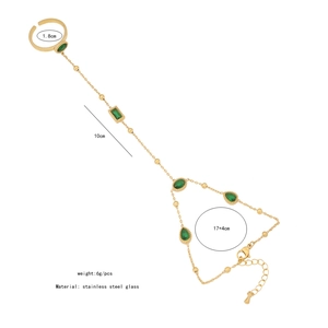 Detail view of gold hand chain with green glass stones and full size specifications