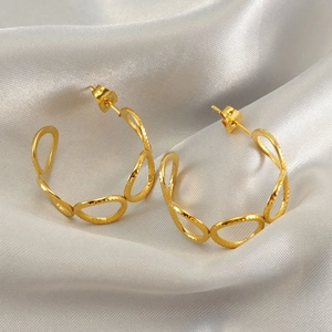Chic hollow circular stainless steel hoop earrings for women on silver silk background