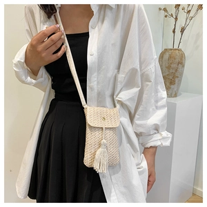 Straw crossbody bag with tassel for women, beige woven texture on white shirt model