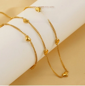 Detalle del collar de acero inoxidable chapado en oro con colgantes de corazón en soporte