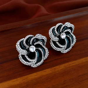 Macro shot of flower earrings featuring black enamel petals and crystal accents