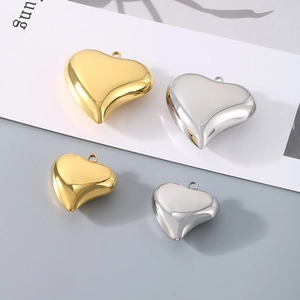 Detailed view of hollow heart pendants in gold and silver finishes and various sizes