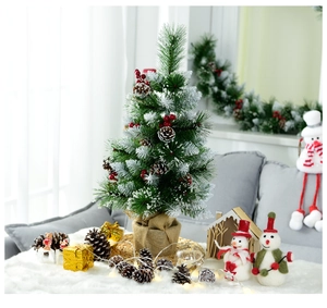 Detailed view of a 60cm mini snowy Christmas tree with red berries and burlap base