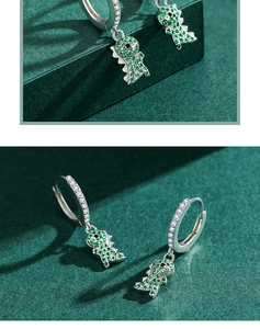 Detail view of s925 silver dinosaur earrings with green and clear zircon stones