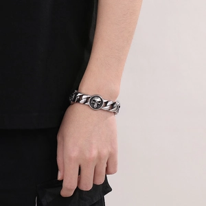 Vintage silver mens cuban link bracelet featuring a detailed skull charm on a round base