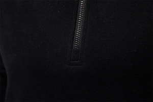 Detailed macro view of the metal zipper and knit fabric texture on a black hoodie