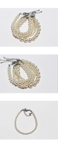 Close-up of white round pearl necklaces with silver lobster clasps and extension chains