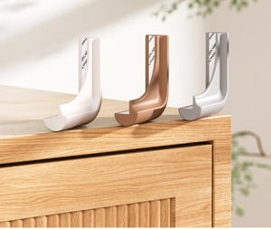 Detailed view of L-shaped silicone corner guards in white, bronze and silver for child safety