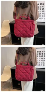 Detailed view of the diamond quilted wine red tote bag with adjustable shoulder strap