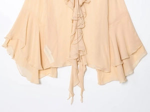 Detail of multi-layered ruffles and delicate stitching on a beige chiffon blouse