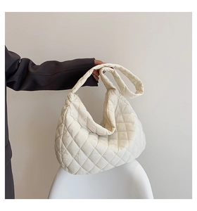 Detail of white quilted cloud bag featuring soft texture and spacious dumpling style design