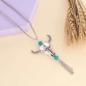 Detail of silver bull skull pendant with turquoise beads and metallic fringe on a box chain