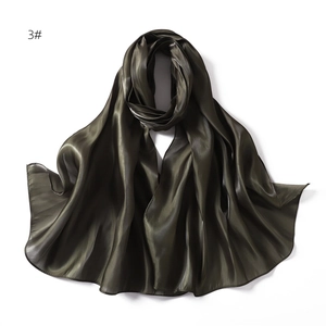Macro view of silky dark olive green satin scarf with glossy texture and smooth drape