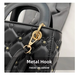 Detailed macro view of golden rabbit embroidery and metallic hook on quilted leather bag