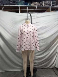 Détail macro d'un chemisier rose à manches longues avec imprimé paisley noir et col classique