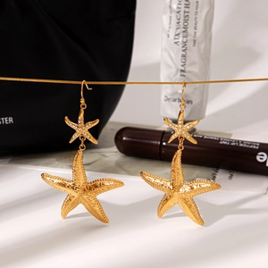 Detail of 18k gold starfish earrings featuring sparkling rhinestones and frosted metal texture