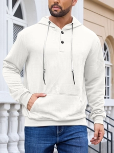 Detail of white jacquard hoodie featuring button placket and textured fabric on model