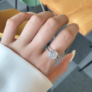 Macro shot of cushion-cut solitaire ring with double-row micro-pave setting on hand