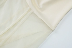 Detailed macro view of off-white mesh stitching and smooth fabric on the summer dress