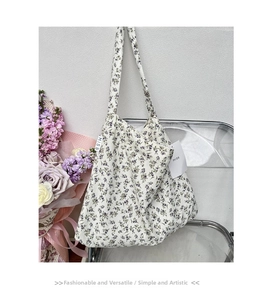Detailed macro view of white floral canvas tote bag featuring purple flower print and MISS tag