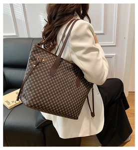 Detail of vintage geometric plaid tote bag featuring dark brown handles and metal ring accents